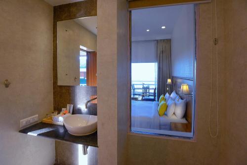 a bathroom with a sink and a mirror at TreeHouse Chail Villas in Chail