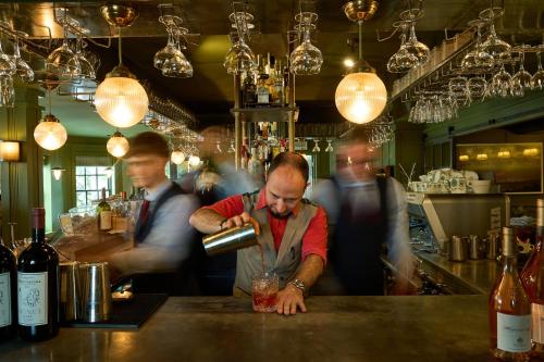 a man standing at a bar making a drink at The Mitre, Hampton Court in Kingston upon Thames