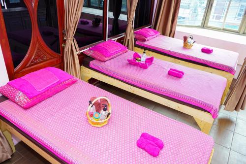 three beds in a room with pink sheets and pink napkins at Marine paradise Encore in Pattaya South