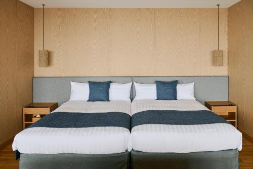 a bedroom with a large bed with blue and white pillows at samana hotel Yakushima in Yakushima