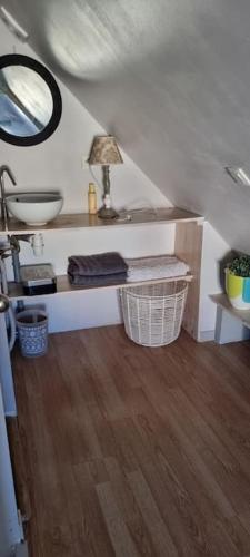 La salle de bains est pourvue d'un lavabo et d'une table avec un miroir. dans l'établissement La petite maison en champagne, à Payns