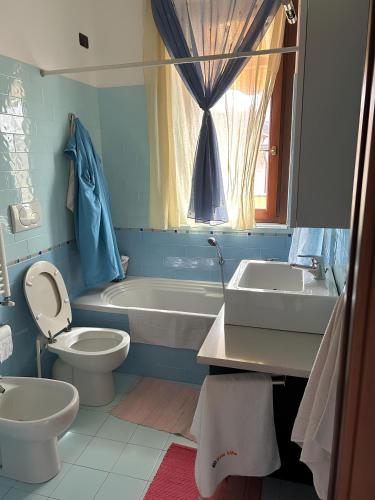 a bathroom with a toilet and a tub and a sink at Appartamento Antony's House in Limbiate