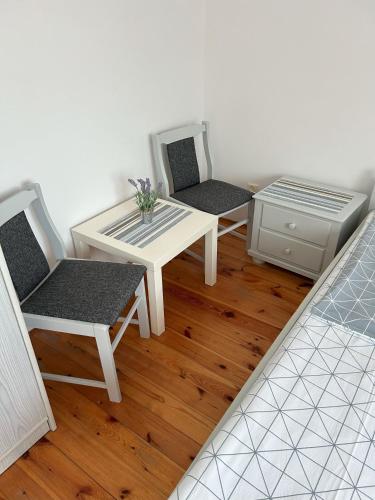 a room with three chairs and a table and a desk at Domek letniskowy przy lesie in Rowy