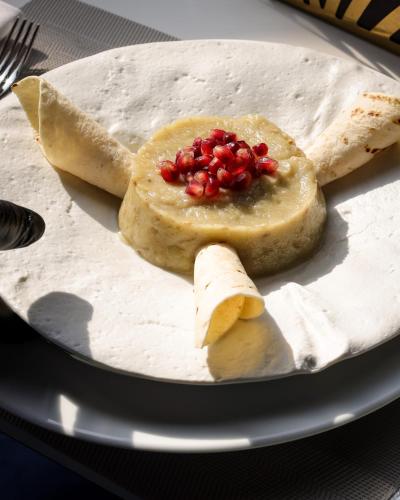 a plate of food with pomegranates and bread on it at Elexus Predeal in Predeal
