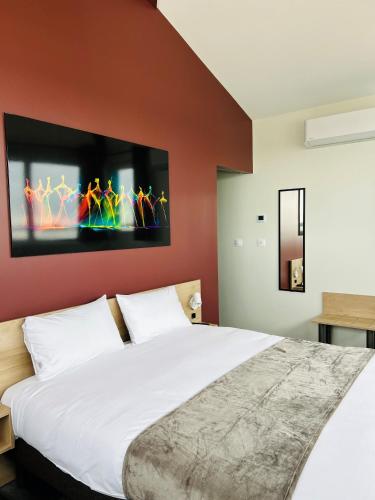 a bedroom with a large white bed with a red wall at Hotel Wood Inn Bordeaux Aéroport in Mérignac