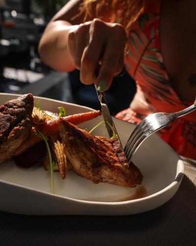 a person eating a plate of food with a fork and knife at Elexus Predeal in Predeal