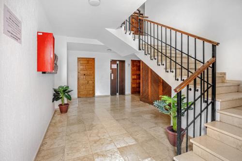 a hallway with stairs and potted plants at Chipiona Centro y Playa in Chipiona