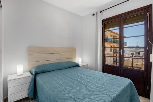 a bedroom with a bed and a large window at Chipiona Centro y Playa in Chipiona