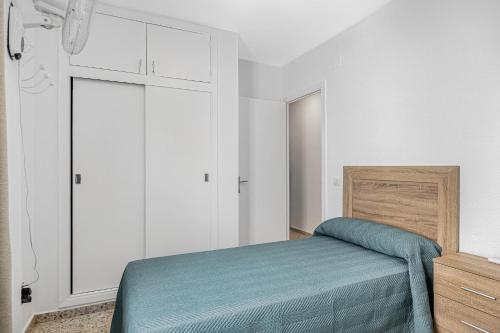 a bedroom with a bed with a blue blanket at Chipiona Centro y Playa in Chipiona