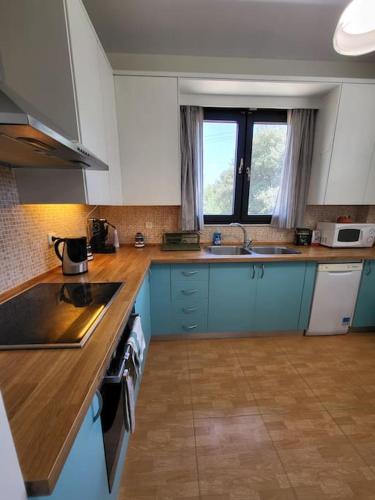 a kitchen with blue cabinets and a counter top at Villa Coppa in (( Kermetés ))