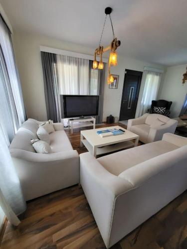 a living room with two white couches and a tv at Villa Coppa in (( Kermetés ))