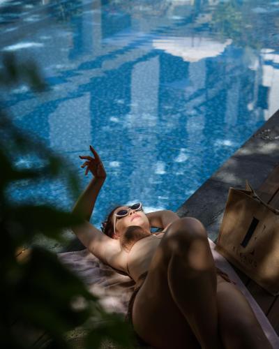 a woman laying on a bed next to a swimming pool at Elexus Predeal in Predeal