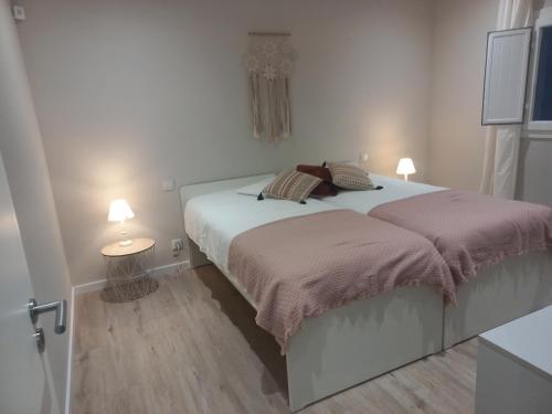 a bedroom with a bed with two pillows on it at Casinha de Santo Amaro in Ourém