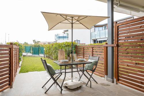 a table and chairs with an umbrella on a patio at H11 LUXURY 3B - Porto - Piscina - Jacuzzi in Santo Stefano al Mare