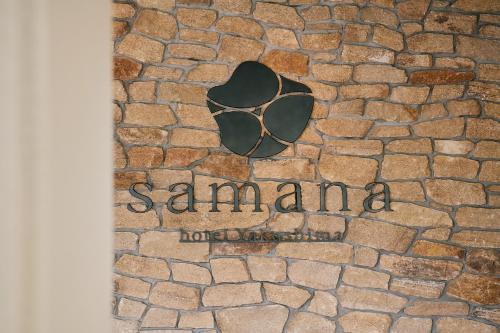 a sign on the side of a stone building at samana hotel Yakushima in Yakushima