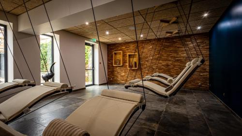 a waiting room with chairs and a brick wall at Hôtel SPA du Lac de Madine - Maison DRAPIER in Heudicourt-sous-les-Côtes