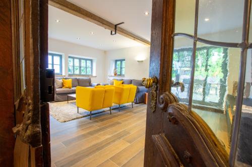 a living room with yellow chairs and a couch at Michels Mühle - Pitt sin Atelier in Brilon