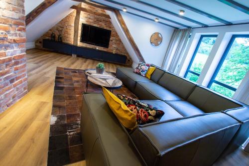 a living room with a couch and a brick wall at Michels Mühle - Pitt sin Atelier in Brilon