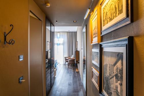 a hallway with paintings on the wall and a living room at Grand Hotel Billia in Saint Vincent