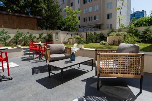 a patio with two chairs and a table and some tables at Aurora Sofia in Sofia