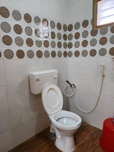 a bathroom with a toilet and a shower at VPR Guest House in Yelagiri