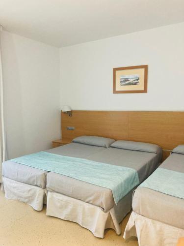 a bedroom with two beds and a picture on the wall at Hotel Vent de Mar in Puerto de Sagunto