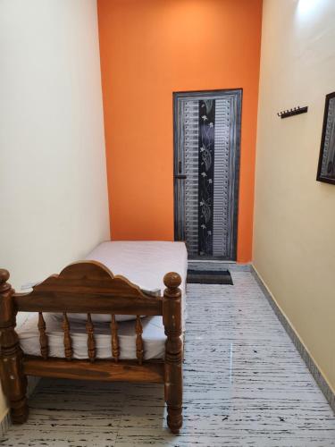 a bedroom with a bed and a black door at VPR Guest House in Yelagiri
