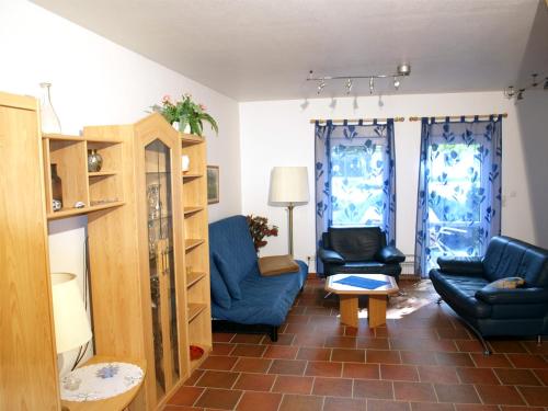 a living room with two blue chairs and a table at Ferienhof Nonnevitzer Strand, Typ B in Dranske
