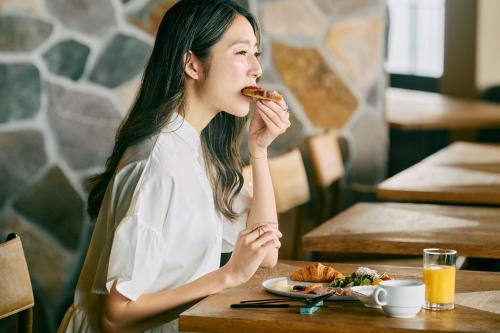 a woman sitting at a table eating food at samana hotel Yakushima in Yakushima