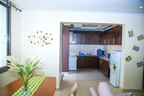a kitchen with a table with a vase on it at IZA Serene city centre apartments in Kigali