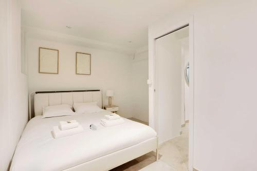une chambre avec un lit blanc avec deux serviettes dessus dans l'établissement Cosy apartment - 1BR-6P - Batignolles, à Paris