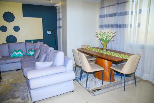 a living room with a couch and a table and chairs at IZA Serene city centre apartments in Kigali
