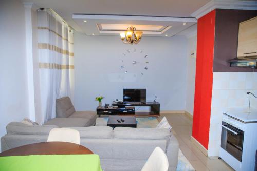 a living room with a couch and a clock on the wall at IZA Serene city centre apartments in Kigali