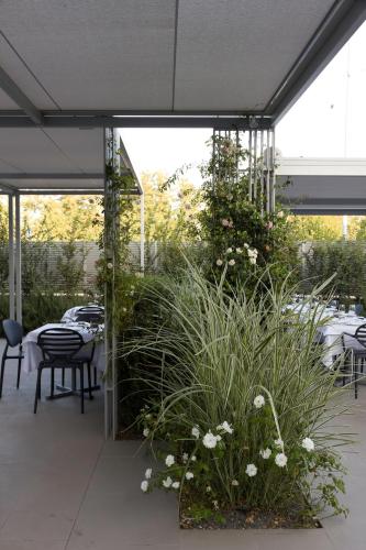 a patio with tables and chairs and plants at Locanda La Gazzella in Maranello
