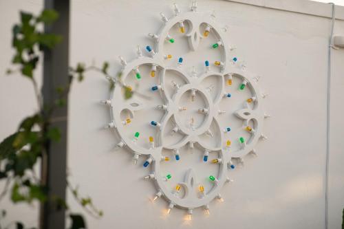 a white clock on a wall with lights at Trulli Arborea in Alberobello