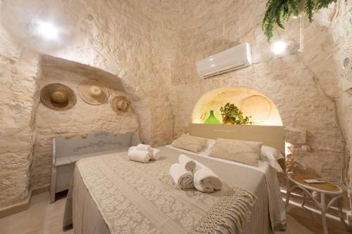 a bedroom with a bed with towels on it at Trulli Arborea in Alberobello
