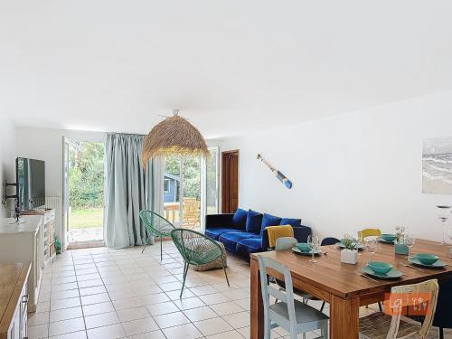 un salon avec une table et un canapé bleu dans l'établissement Au Ptit Bouchon Villa Golf, à Wimereux