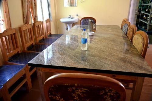 a bottle of water sitting on a table in a room at RAHUL Homestay in Sainj