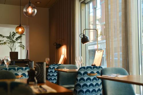 a restaurant with blue chairs and tables and a window at Quality Hotel The Mill in Malmö