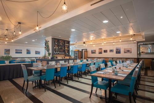 a dining room with long tables and blue chairs at Grande Albergo in Sestri Levante