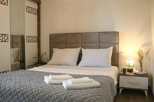 a bedroom with a bed with two towels on it at Lazare in Batumi