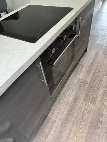 a kitchen with wooden floors and a counter top at 2 Bed Apartment Scarisbrick Street Ormskirk - Rooms by Vici in Ormskirk