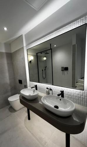 a bathroom with two sinks and a large mirror at The Queen at Chester Hotel, BW Premier Collection in Chester