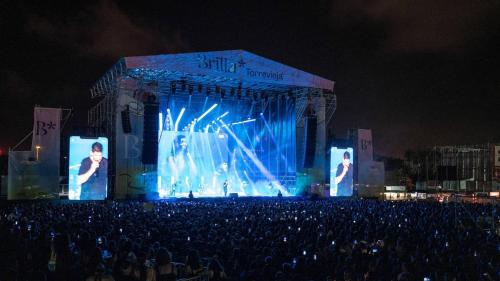 a crowd of people watching a concert at night at Blue house 1ª linea playa in Torrevieja