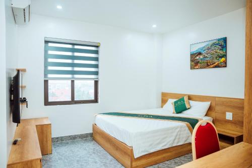 ein Schlafzimmer mit einem Bett und einem Fenster in der Unterkunft Gala Hotel & Apartment in Haiphong