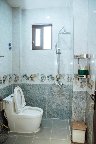 a bathroom with a toilet and a glass shower at Gala Hotel & Apartment in Hai Phong