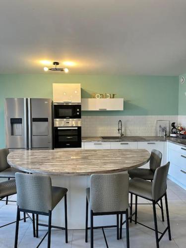 - une cuisine avec une grande table et des chaises dans l'établissement Spacieux Appartement de 73 m2 en plein centre-ville d'Evian avec 2 chambres, à Évian-les-Bains