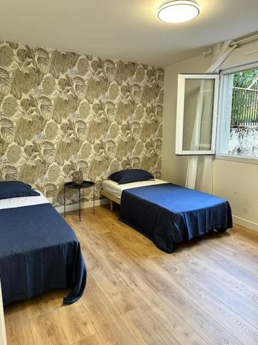 une chambre avec deux lits et un mur en pierre dans l'établissement Spacieux Appartement de 73 m2 en plein centre-ville d'Evian avec 2 chambres, à Évian-les-Bains