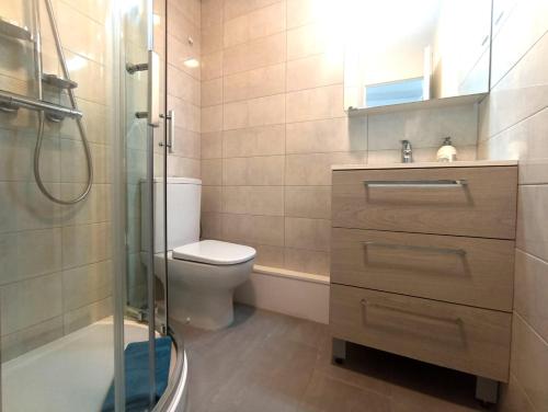 une salle de bain avec toilettes et douche en verre dans l'établissement Le Saphir - Plage du Mole, au Cap d'Agde