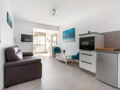 une cuisine et un salon avec un canapé et une table dans l'établissement Le Saphir - Plage du Mole, au Cap d'Agde